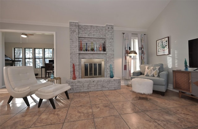 living room with a brick fireplace, ceiling fan, vaulted ceiling, and tile patterned floors