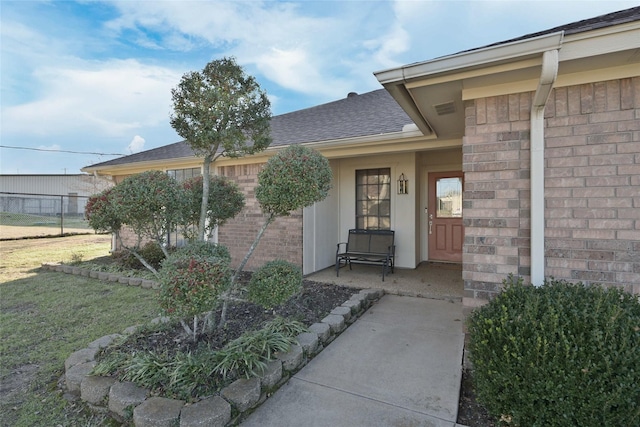 view of exterior entry with a lawn