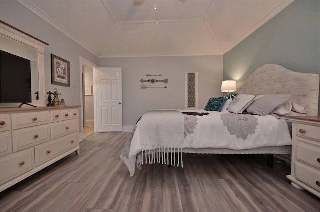 bedroom with ornamental molding, lofted ceiling, and wood-type flooring