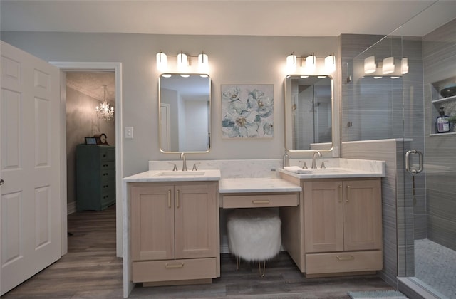 bathroom featuring a notable chandelier, an enclosed shower, vanity, and wood-type flooring