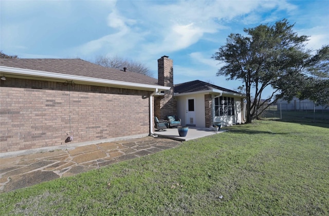 rear view of property featuring a patio and a lawn