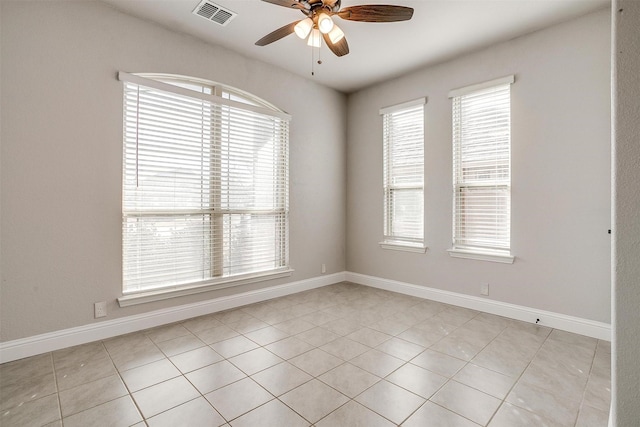 spare room with ceiling fan and light tile patterned flooring