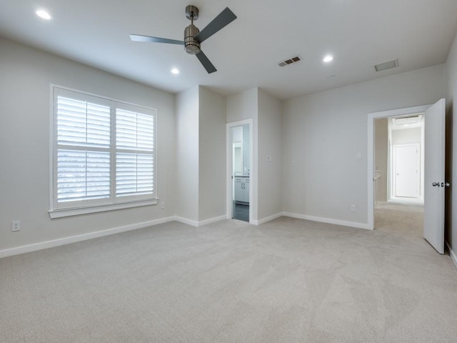 unfurnished bedroom featuring ceiling fan, ensuite bathroom, and light carpet