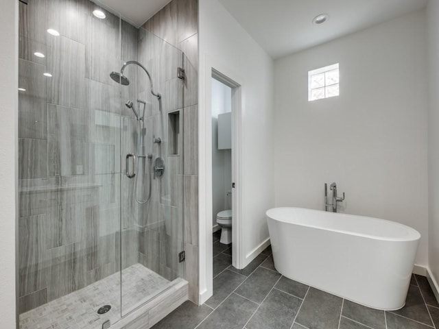 bathroom featuring toilet, tile patterned floors, and independent shower and bath