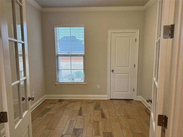 spare room featuring crown molding and light wood-type flooring