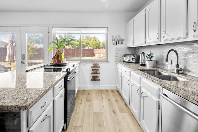 kitchen featuring stainless steel dishwasher, white cabinetry, black range with electric stovetop, and sink