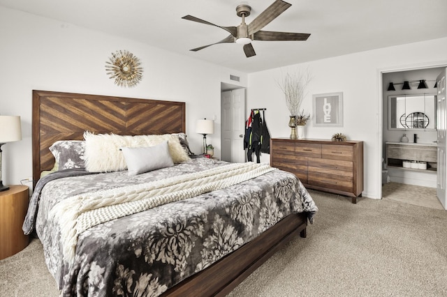 carpeted bedroom with ensuite bathroom and ceiling fan