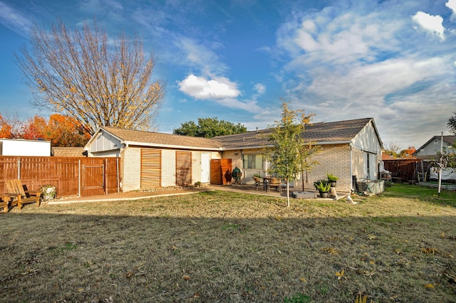 rear view of house featuring a patio and a yard