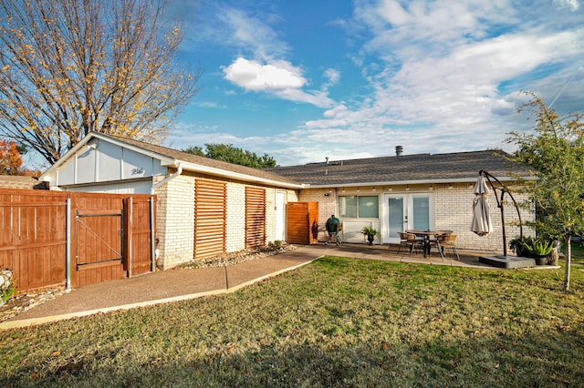 rear view of house with a patio area and a yard