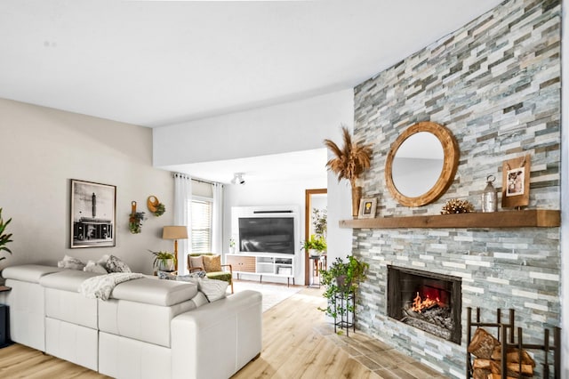 living room with light wood-type flooring and a fireplace