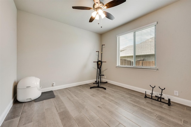 exercise area with ceiling fan and light wood-type flooring