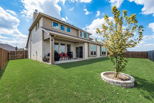 rear view of house featuring a lawn and a patio