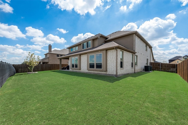 rear view of property with a lawn and central air condition unit