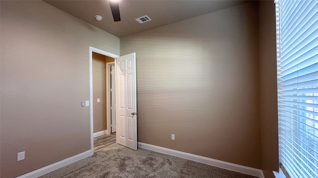 spare room featuring light carpet and ceiling fan