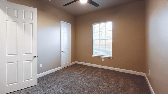 unfurnished bedroom with ceiling fan and dark carpet