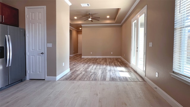 kitchen with ceiling fan, stainless steel fridge, light hardwood / wood-style floors, and a tray ceiling