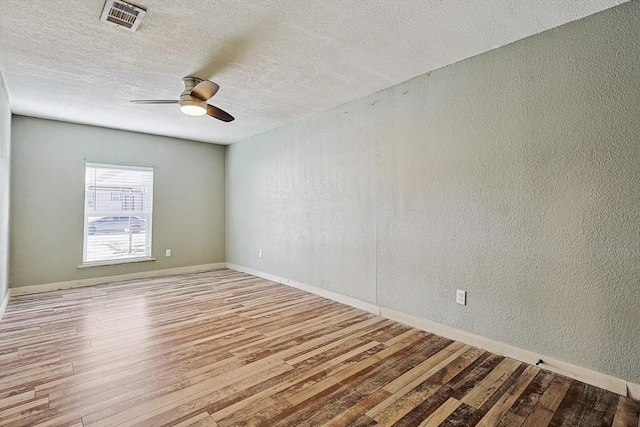 unfurnished room with a textured ceiling, ceiling fan, and light hardwood / wood-style flooring