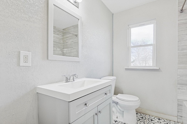 bathroom featuring toilet, walk in shower, and vanity