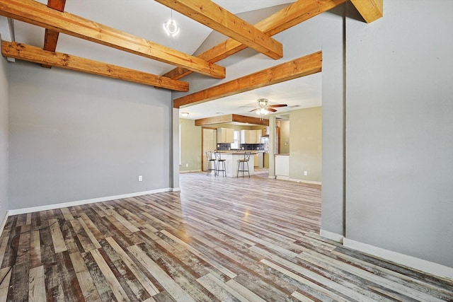 unfurnished living room with beam ceiling, ceiling fan, and light hardwood / wood-style flooring