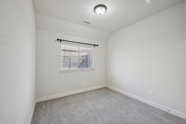 empty room featuring lofted ceiling and carpet