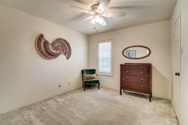 living area with light carpet and ceiling fan