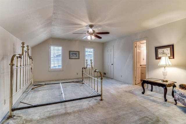 unfurnished bedroom featuring ceiling fan, light colored carpet, connected bathroom, and vaulted ceiling