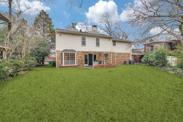 rear view of property with a yard and central air condition unit