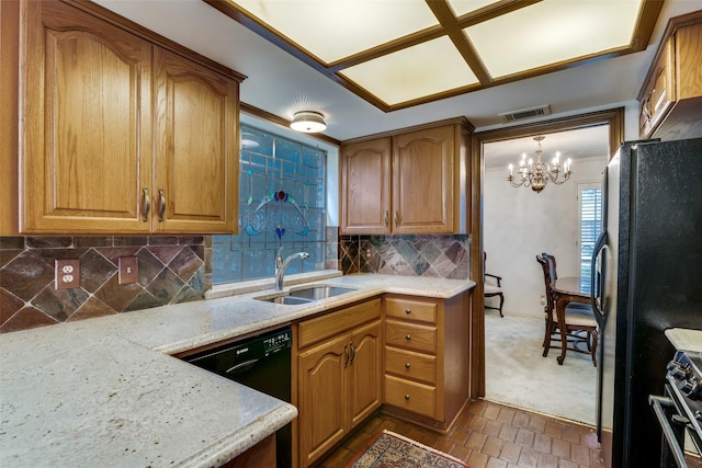 kitchen with decorative light fixtures, sink, backsplash, light stone counters, and black appliances