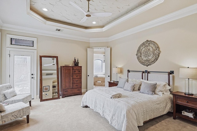 bedroom with ensuite bath, crown molding, a tray ceiling, and carpet flooring