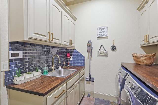 laundry area with cabinets, sink, and washing machine and dryer