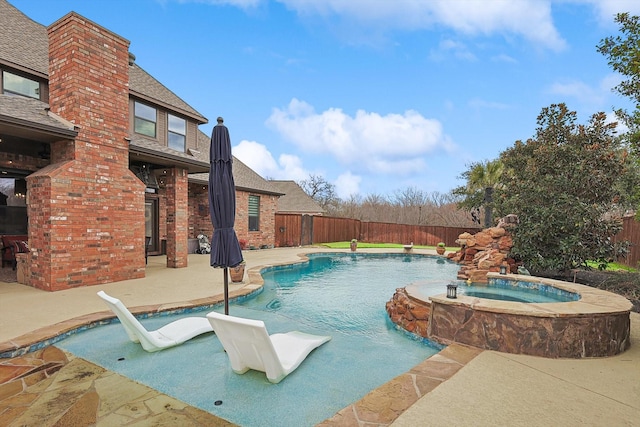 view of pool featuring pool water feature, a patio, and an in ground hot tub