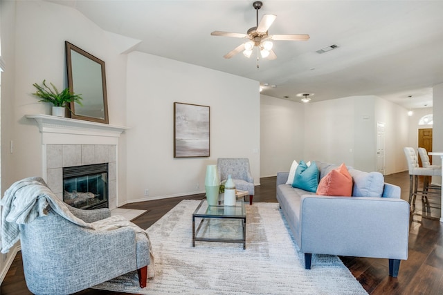 living room featuring a tile fireplace, ceiling fan, and dark hardwood / wood-style floors