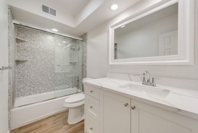 full bathroom featuring combined bath / shower with glass door, vanity, and toilet