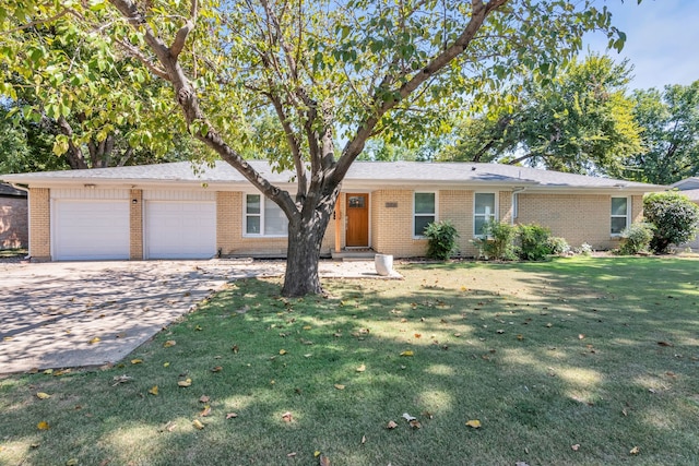 single story home featuring a garage, concrete driveway, brick siding, and a front lawn