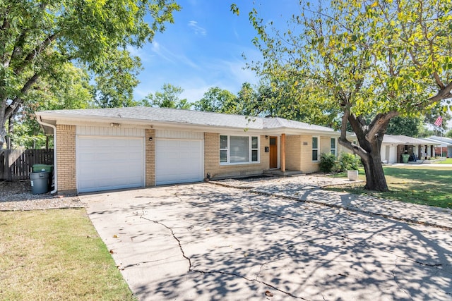 ranch-style house with driveway, brick siding, a front lawn, and an attached garage