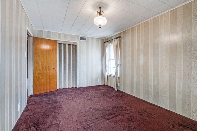 spare room with wooden walls and carpet