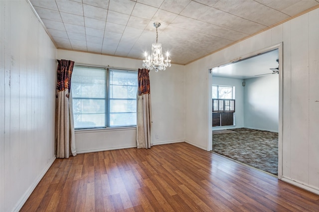 spare room featuring ceiling fan with notable chandelier, hardwood / wood-style flooring, and ornamental molding