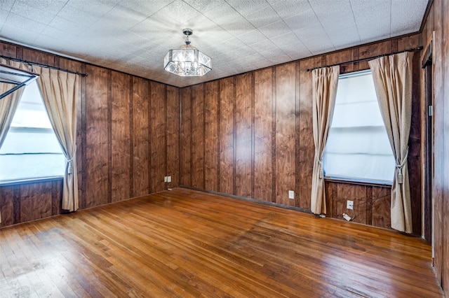 unfurnished room featuring wood walls and hardwood / wood-style floors