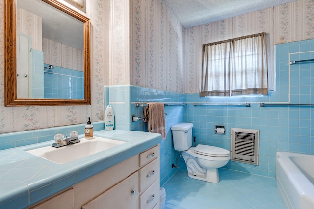 bathroom featuring tile walls, tile patterned floors, heating unit, a bath, and vanity