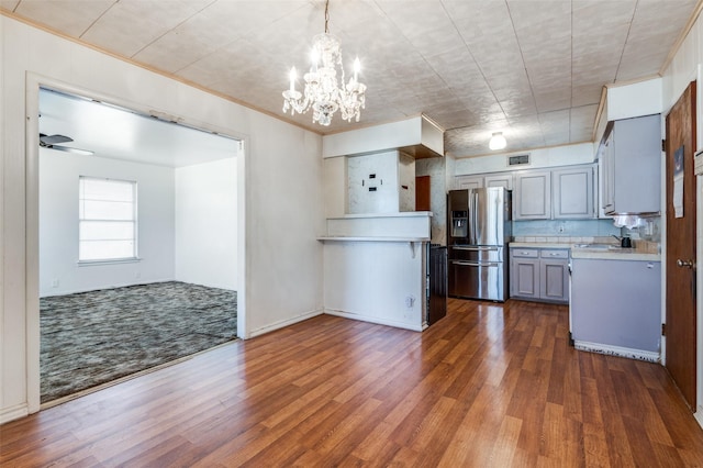 kitchen with ceiling fan with notable chandelier, stainless steel fridge with ice dispenser, gray cabinets, pendant lighting, and dark wood-type flooring