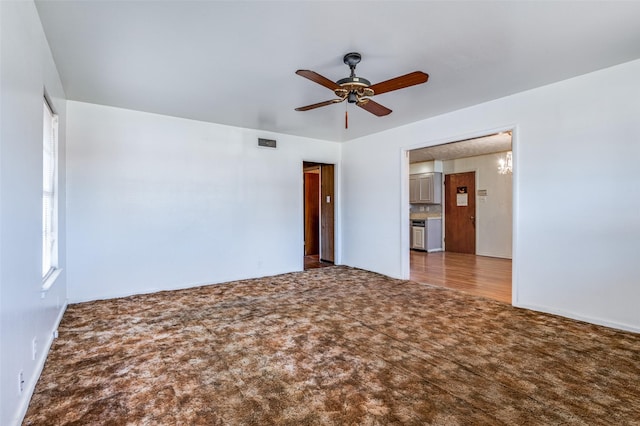 empty room with carpet and ceiling fan with notable chandelier