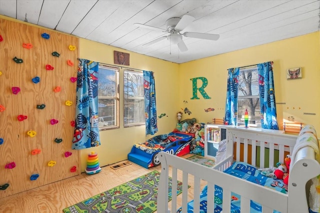 bedroom featuring ceiling fan, wood ceiling, and a crib