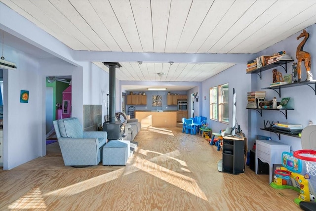 interior space with wooden ceiling, a wood stove, and beamed ceiling