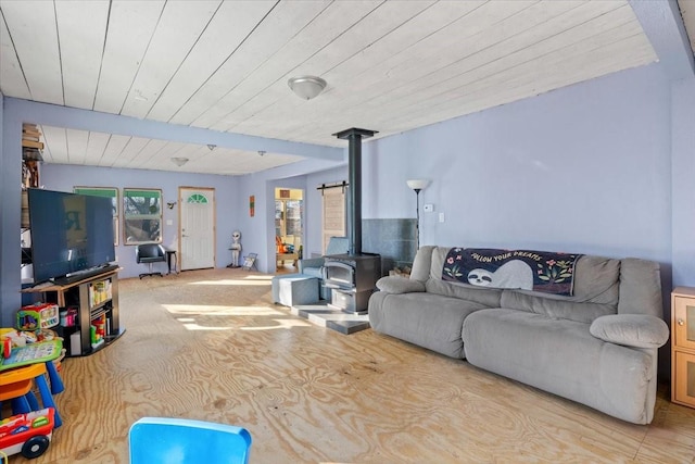 living room featuring a wood stove and wood ceiling