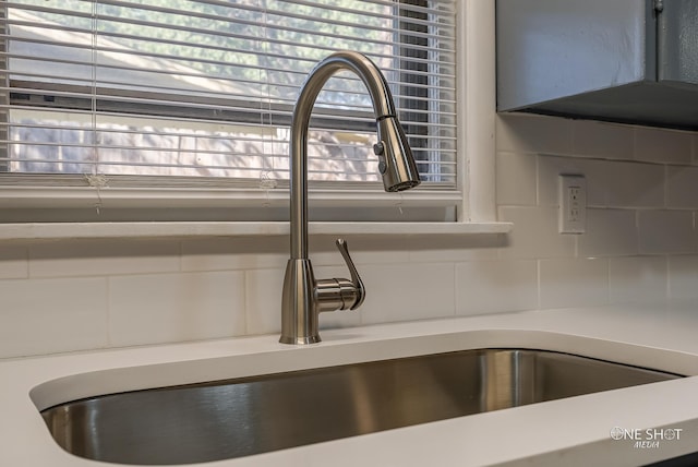 room details featuring sink and decorative backsplash