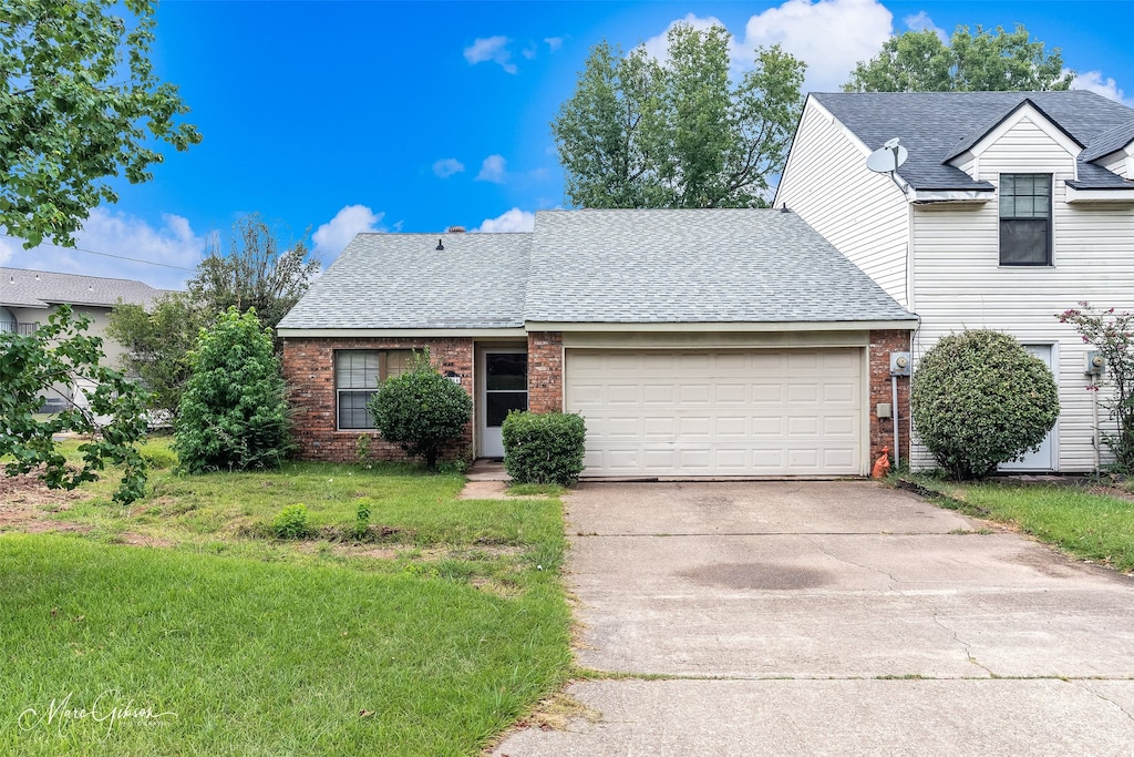 view of front of house with a front yard and a garage