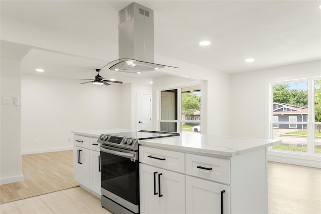 kitchen with white cabinets, stainless steel electric stove, ceiling fan, and island exhaust hood