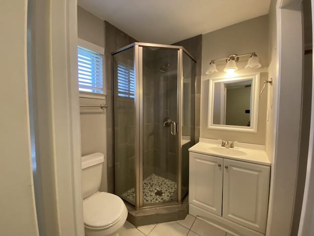 bathroom with toilet, an enclosed shower, and tile patterned flooring