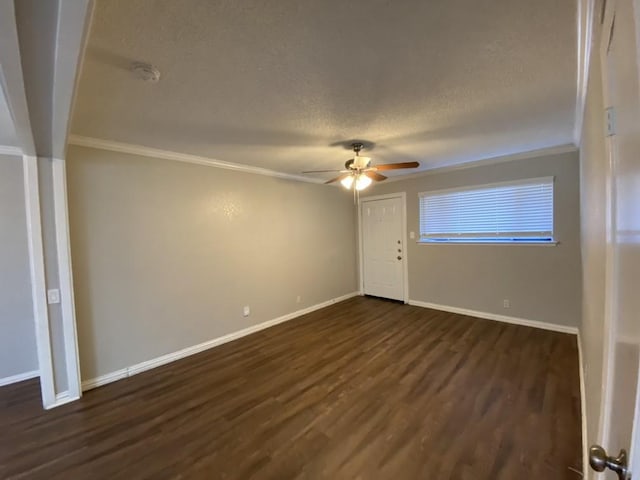 empty room with a textured ceiling, dark hardwood / wood-style flooring, crown molding, and ceiling fan