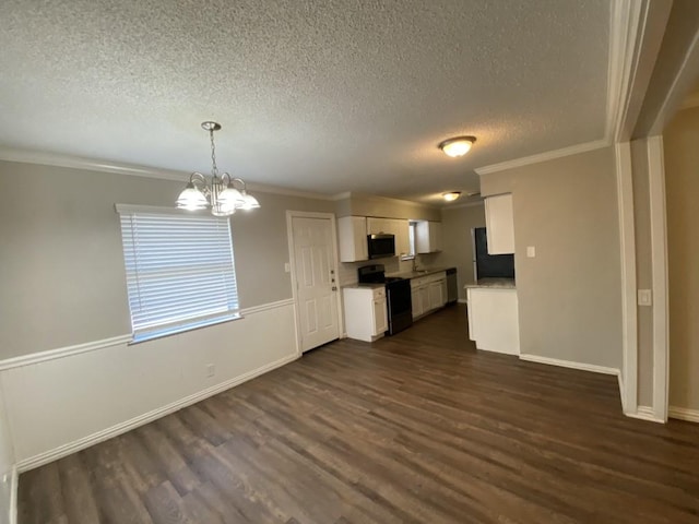 kitchen featuring refrigerator, pendant lighting, a notable chandelier, black range with electric stovetop, and white cabinetry